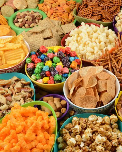 Bowls of assorted snacks: crisps, crackers, pretzels, nuts and popcorn